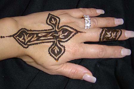 Tribal cross tattoo on the back of your fingers